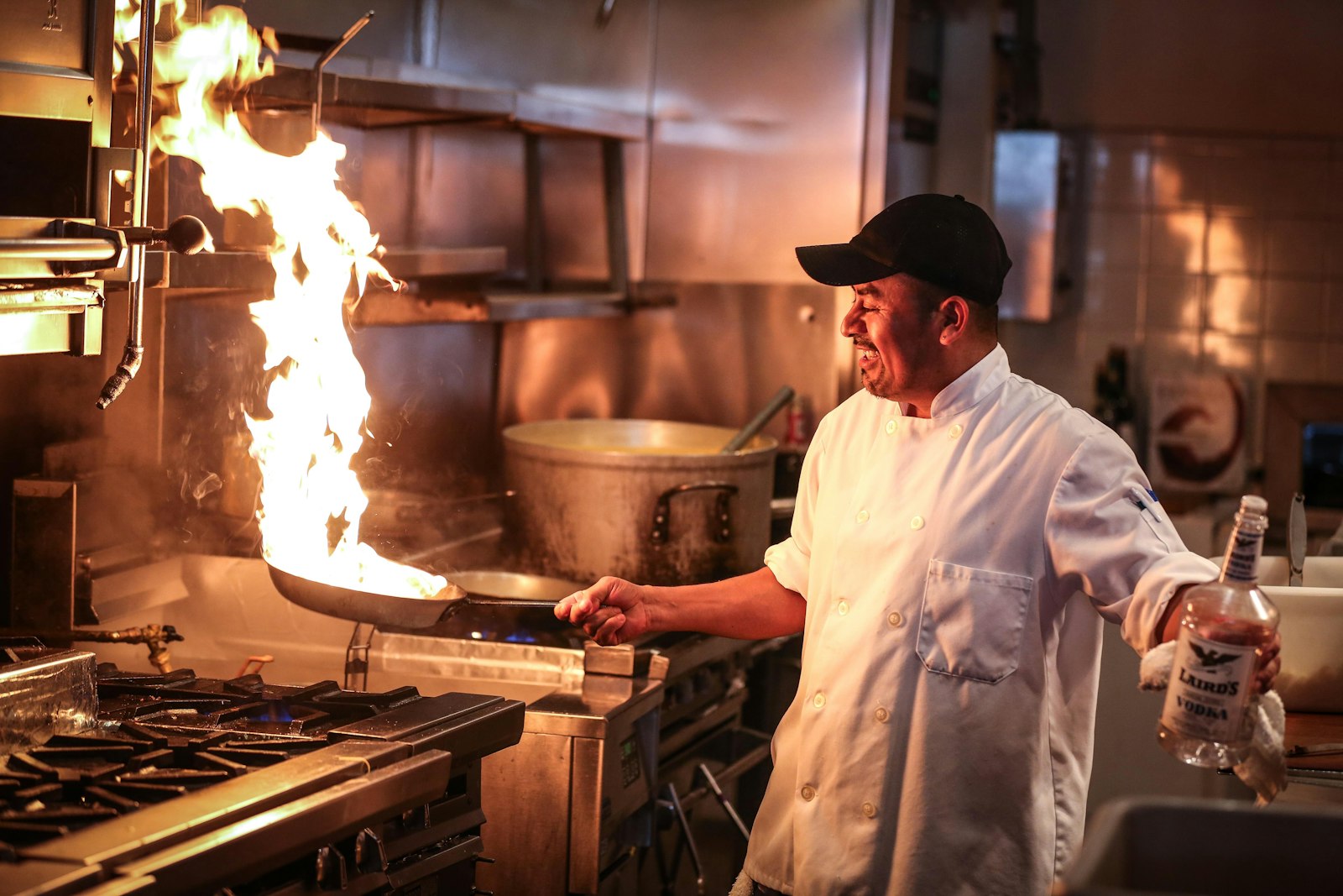 Chef finishing a dish with a flambe in the kitchen