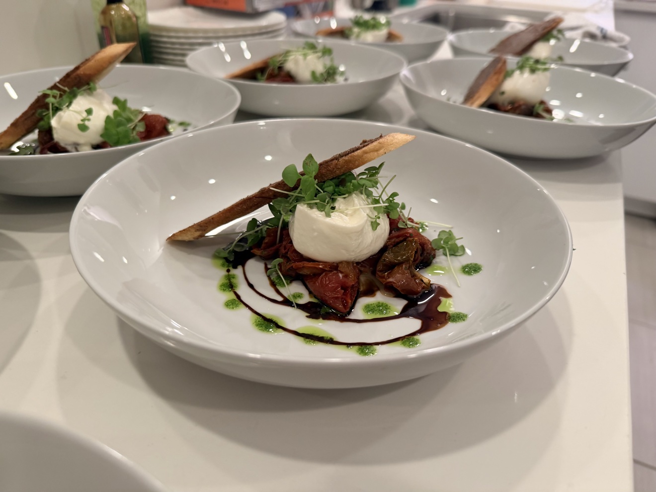 Creamy burrata with roasted tomatoes, balsamic and basil oil