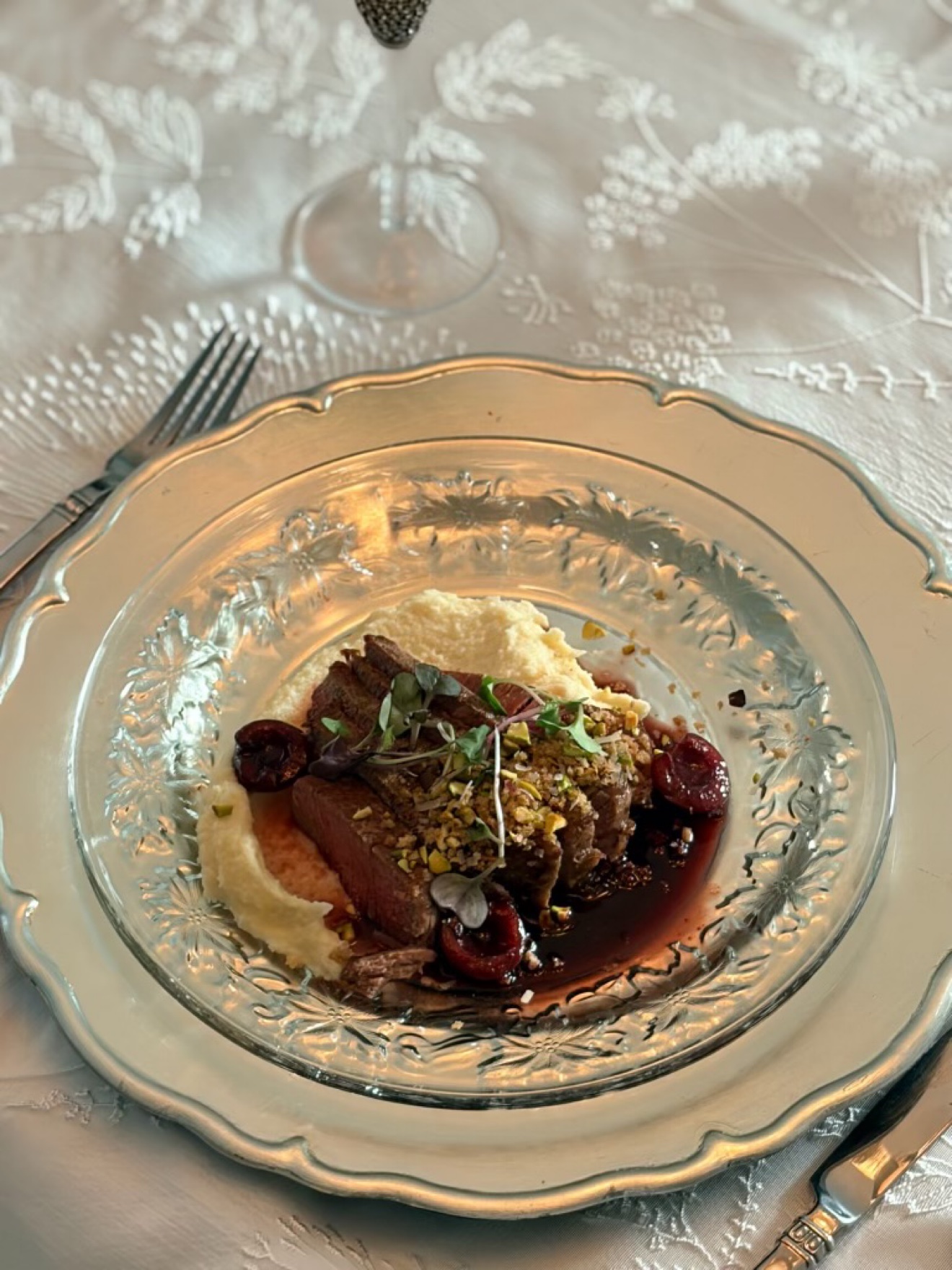 Sliced duck breast with pistachio crust, cherries and parsnip purée